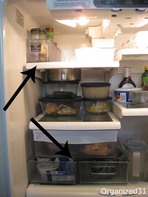 interior shelves of refrigerator with black arrows pointing to clear organizing bins