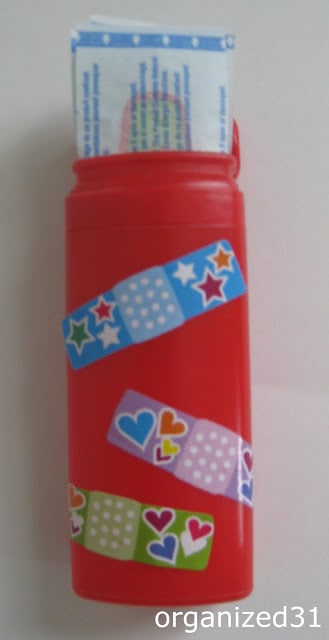 a mentos container decorated with bandaids with bandaids inside the container