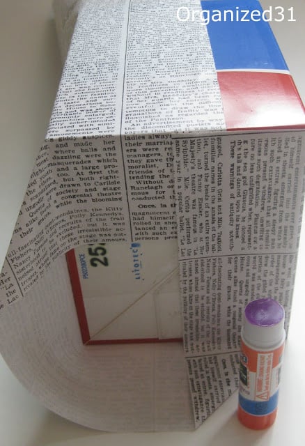 a box being wrapped with newsprint wrapping paper