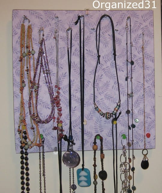 necklaces hung on a decorated corkboard