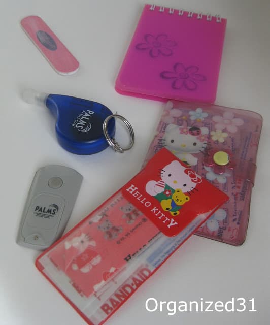 a nail file, pink notebook, Hello Kitty wallet and pouch, tape measure, flashlight