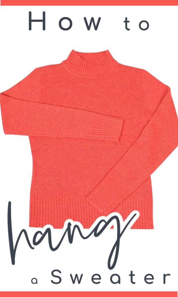 pink sweater laid out flat on white background with sleeves folded over the front.