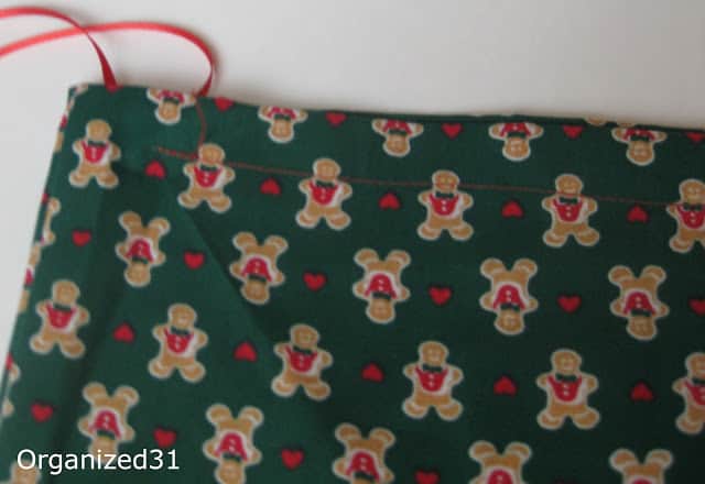 a gingerbread man fabric gift bag with a red ribbon on it