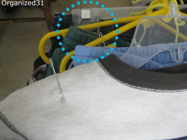 a closeup of a blue circle showing a safety pin attaching pants to a hanger