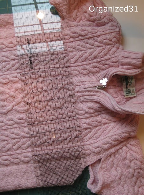 a pink sweater on a cutting mat