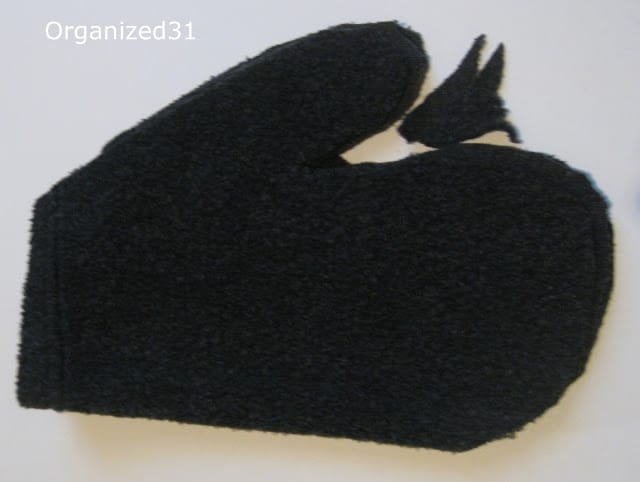 a mitten made from a dark gray sweater
