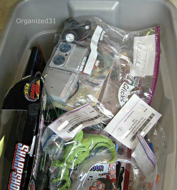 various electronics in bags and boxes in a gray tub