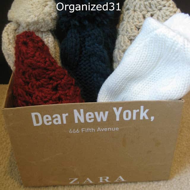 knit hats in a cardboard box with text on it reading Dear New York, 666 Fifth Avenue Zara 