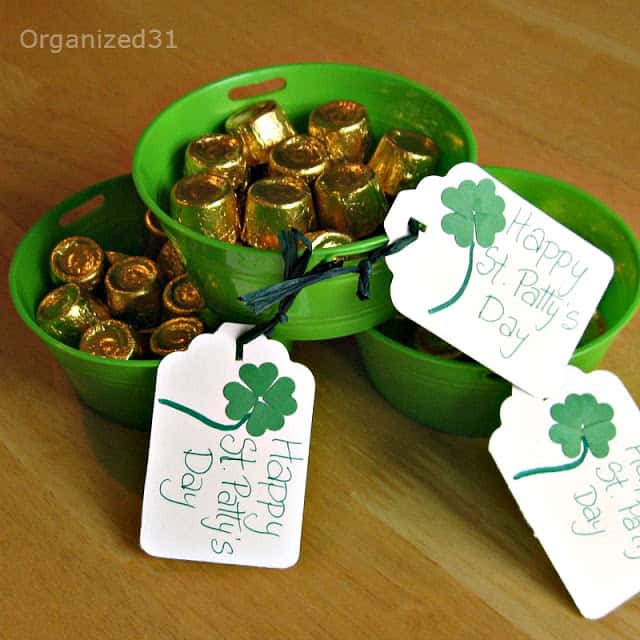 3 green buckets with gold rolo candy in them, with tags on the bowls with text reading Happy St. Patty's Day