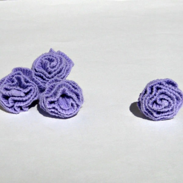 4 purple fabric flowers made from a sweater