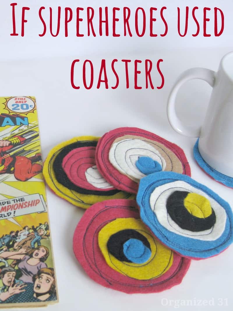 comic book, 4 superhero coasters, and a mug on a coaster.