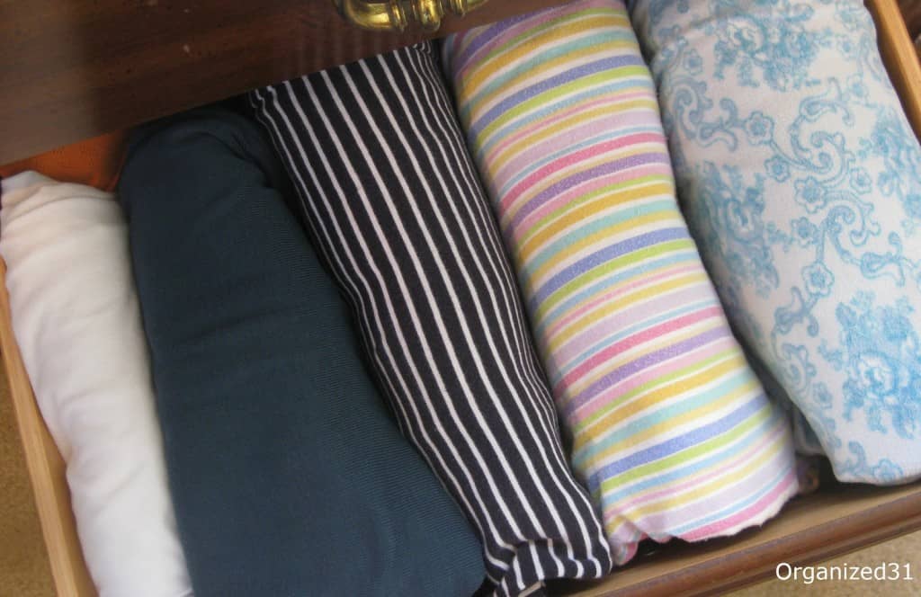 overhead view of colorful, neatly folded pajamas in drawer.