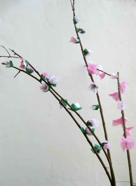 close up of paper cherry blossoms on branches