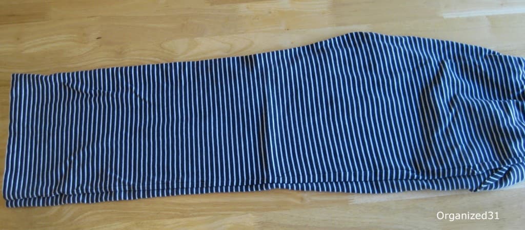 overhead view of navy and white stripe pants folded in half with one leg on top of the other.