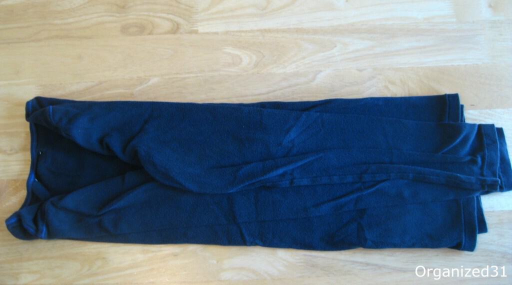 overhead view of partially folded blue shirt on wood table.