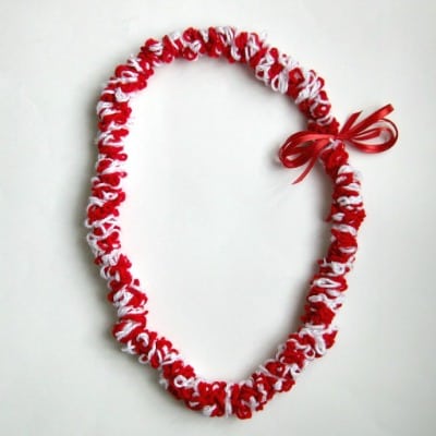red and white yarn lei on white background.