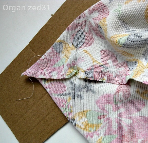 fabric from Hawaiian flower print tank top with new stitches added and piece of cardboard.