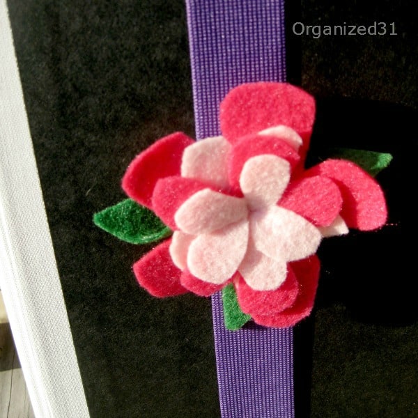 closeup of a felt flower book hugger bookmark on a book