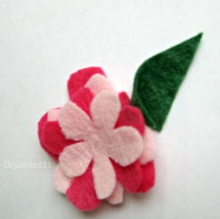 pink and red felt flowers tacked with green leaf.