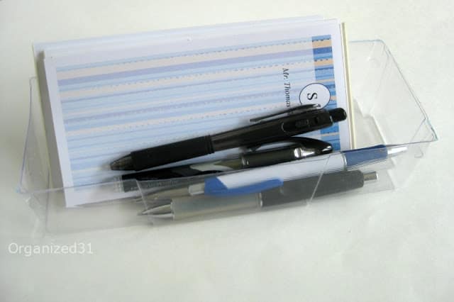 pens and notepads organized in a plastic container