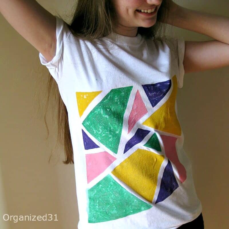 a girl wearing a white t-shirt with a colorful design painted on it