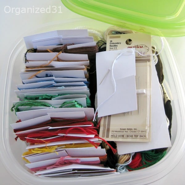 embroidery floss and needles organized in a plastic container