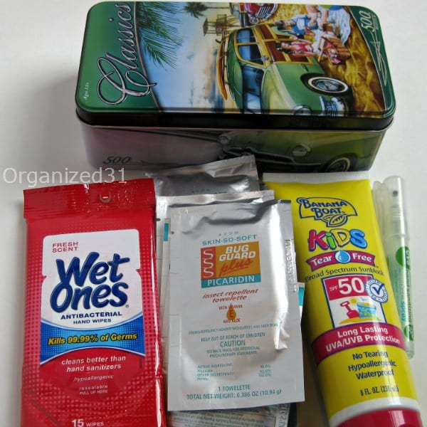 sunscreen, bug guard, and wet ones next to a tin