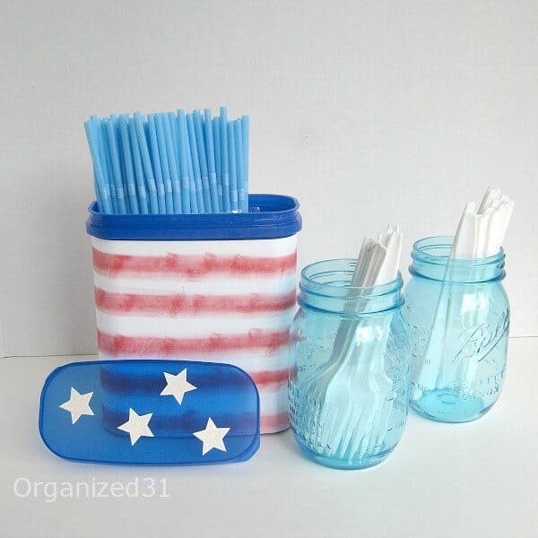 Recycled plastic can used to hold straws, next to 2 mason jars holding plastic silverware