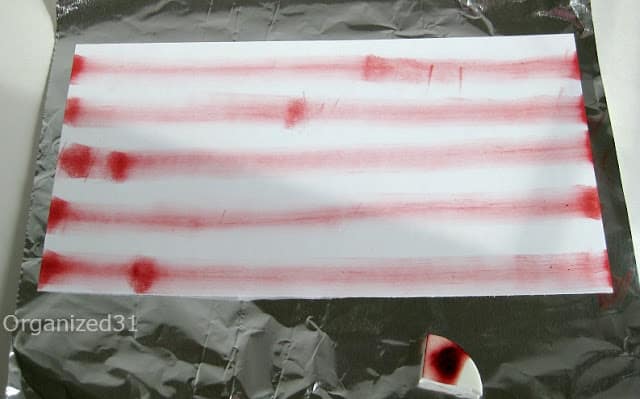 foil with a piece of white cardstock with red stripes on it