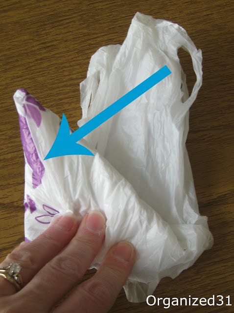 a blue arrow pointing to a hand showing how to fold plastic bags