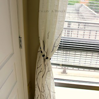 a window with a curtain pulled back using a curtain tie