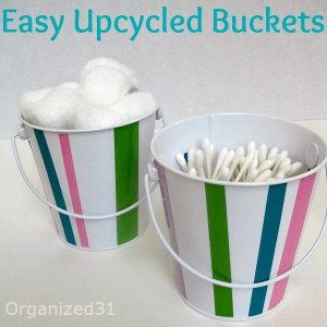 white buckets with colorful stripes filled with cotton swabs and cotton balls