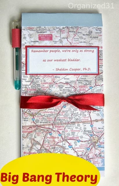 tall narrow note pad with map cover, red ribbon and label saying "Remember people, we're only as strong as our weakest bladder. - Sheldon Cooper, PhD" with title text reading Big Bang Theory