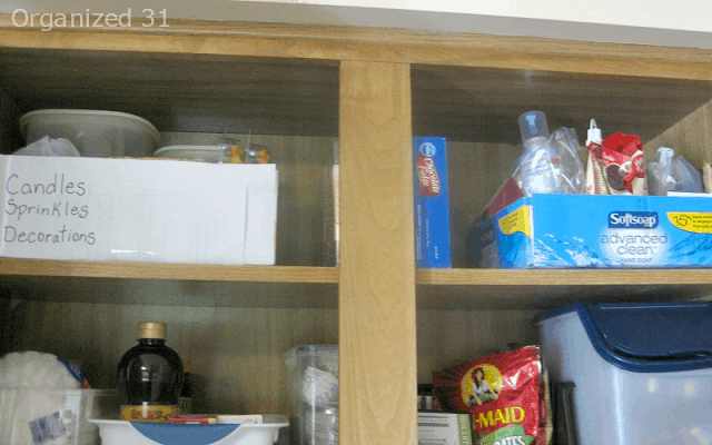 2 different cardboard boxes on upper kitchen cabinet shelf used as organizing bins