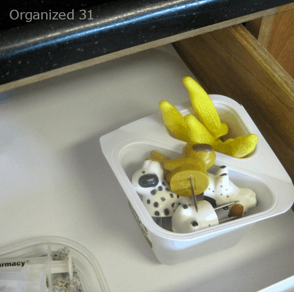 square 2 compartment yogurt cup in kitchen drawer holding corncob holders.