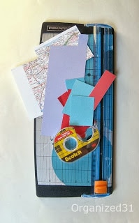 blue paper cutter, with paper scraps and roll of double stick tape
