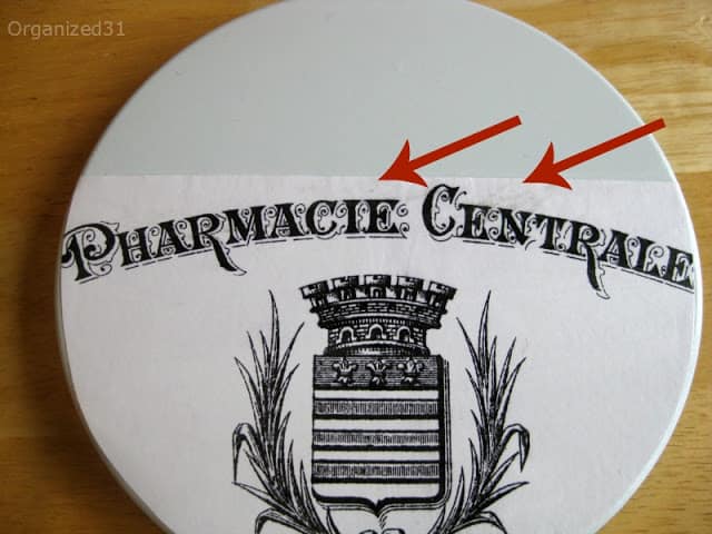 an arrow pointing to where to position the French pharmacy paper on the tin lid