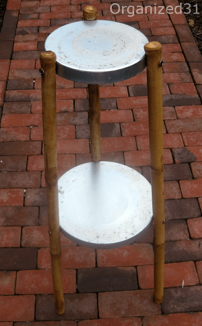 a plant stand on a brick pathway