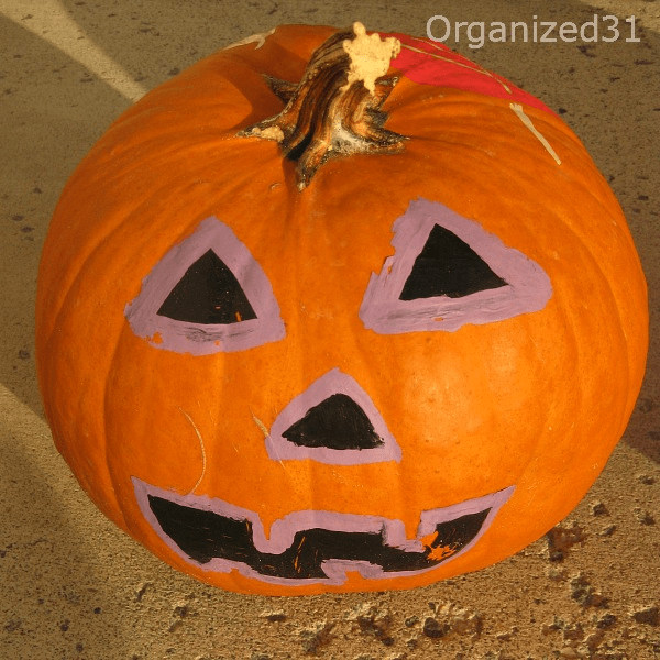 a pumpkin decorated with a painted face for Halloween