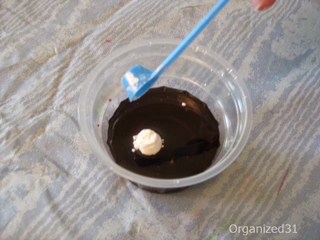 blue measuring spoon dropping white powder into dark colored liquid