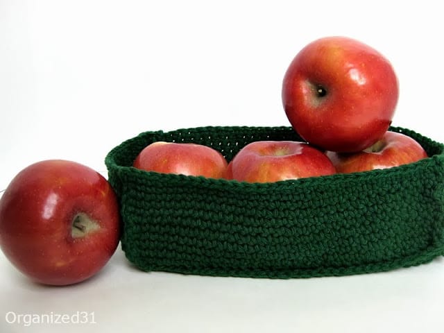 apples in a green Crochet Basket with one apple next to it