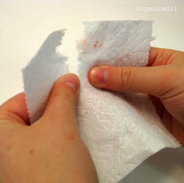 hands tearing apart toilet paper