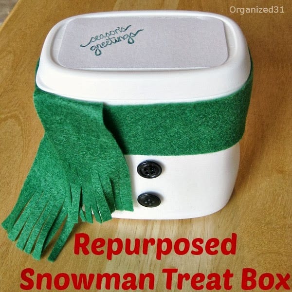 plastic container decorated to look like a snowman's body with a green felt scarf.