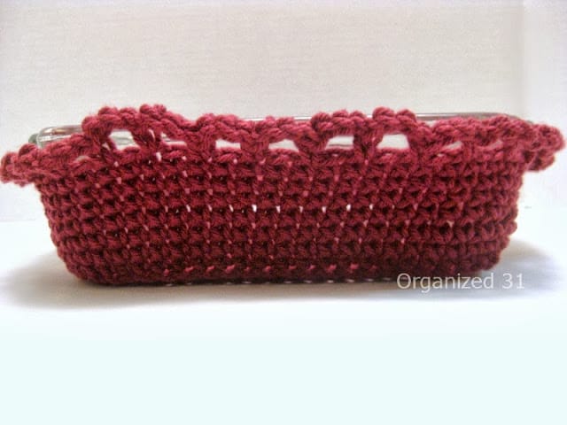 side view of maroon crocheted cozy around glass casserole dish.