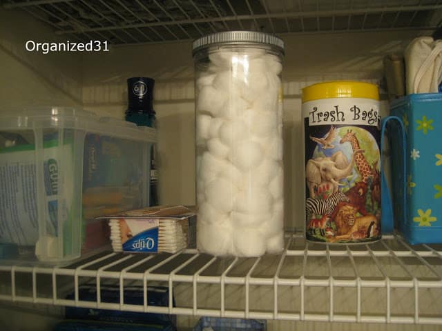 container of cotton balls on shelf with other items