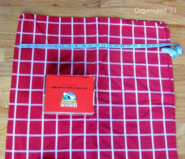 a cardboard box and measuring tape on red and white fabric