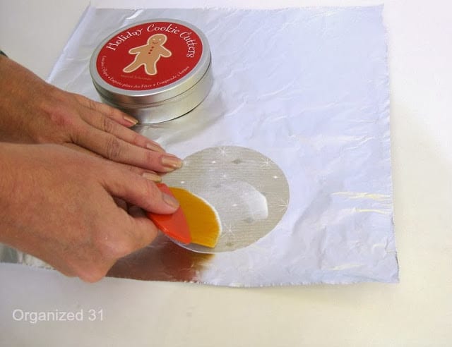 a hand applying mod podge to a paper