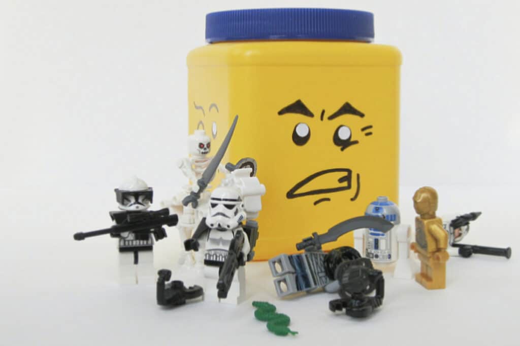 yellow can with blue lid and DIY face to look like LEGO head storage with LEGO figures.