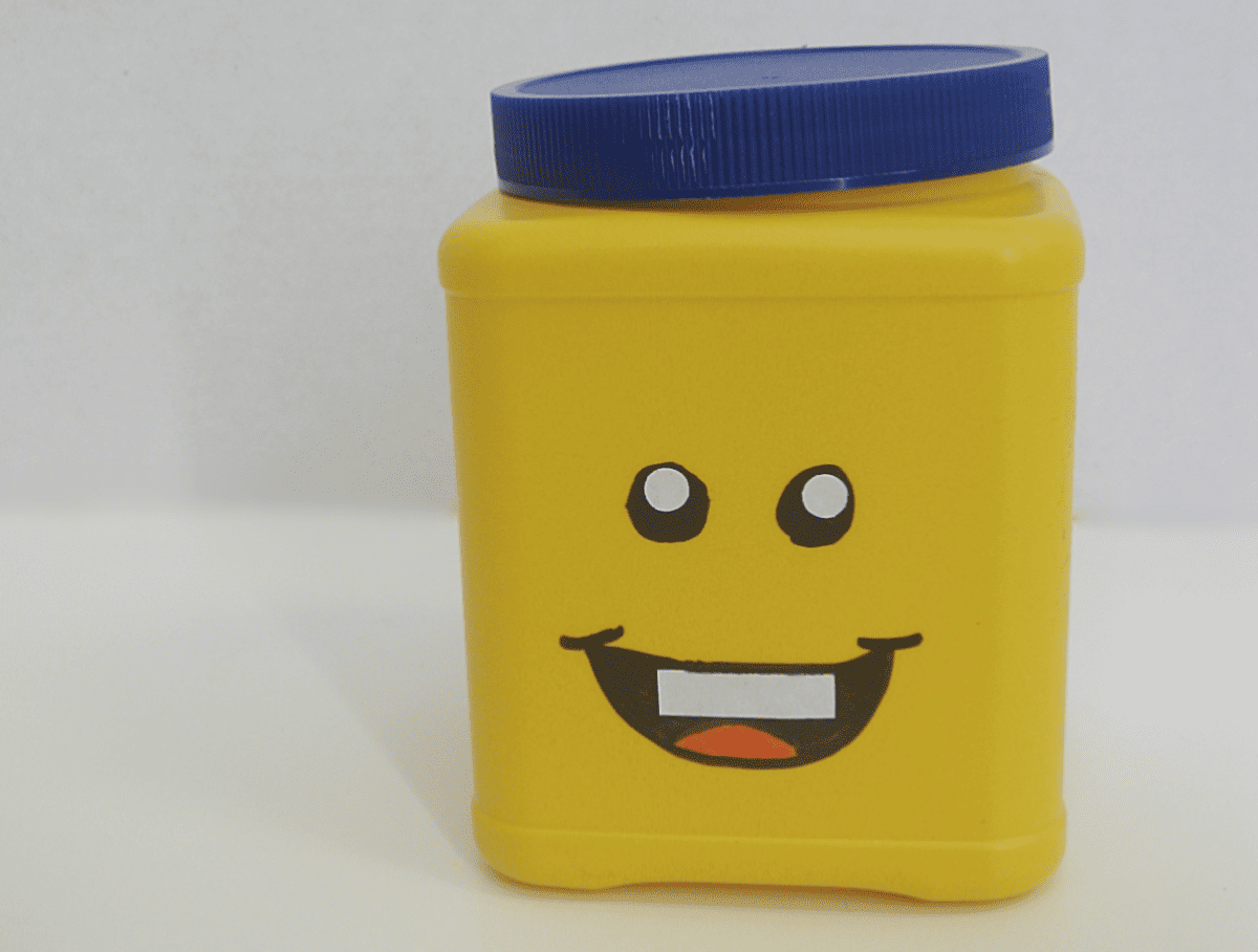yellow can with blue lid and DIY smiling LEGO face.