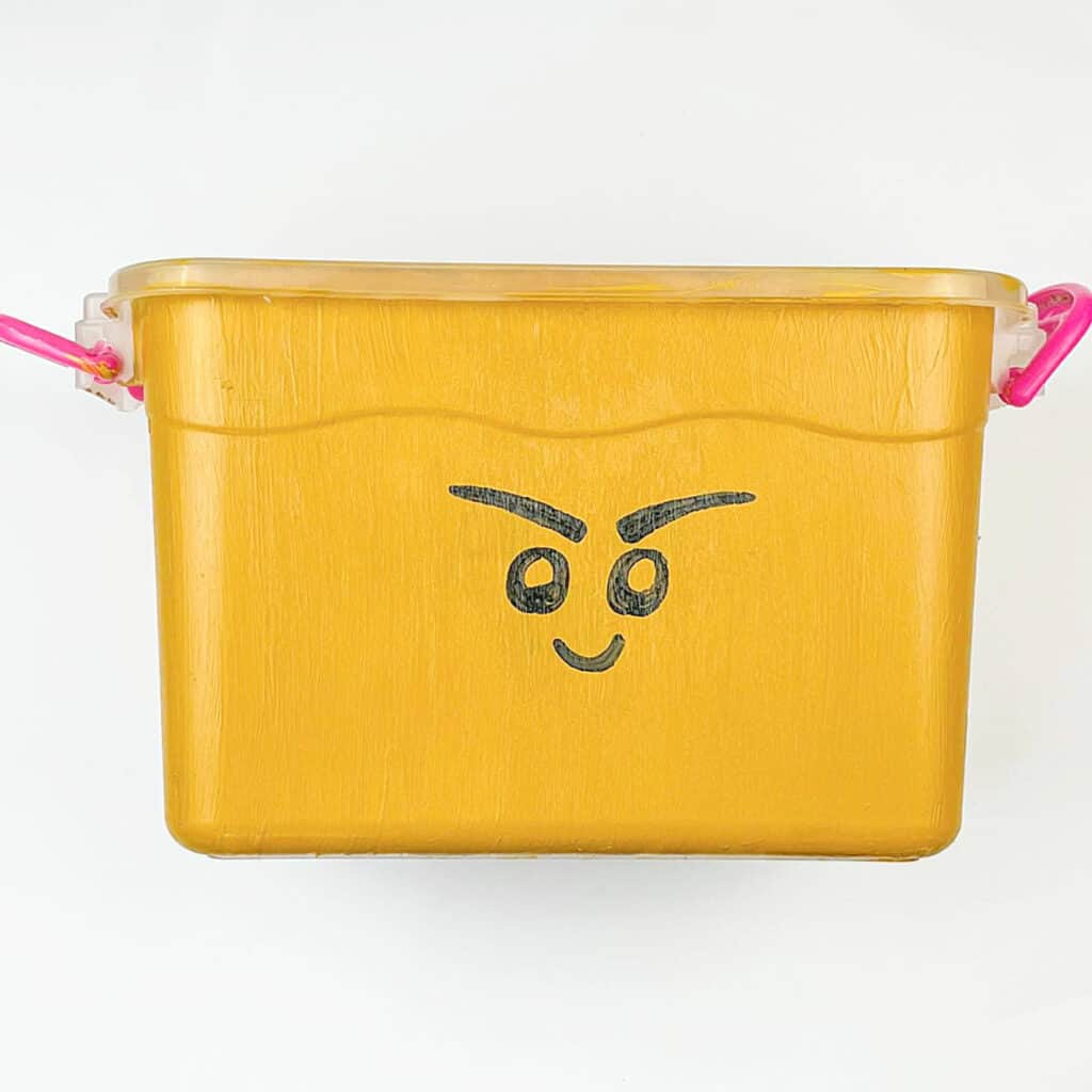 yellow tub with drawn black frowning face.
